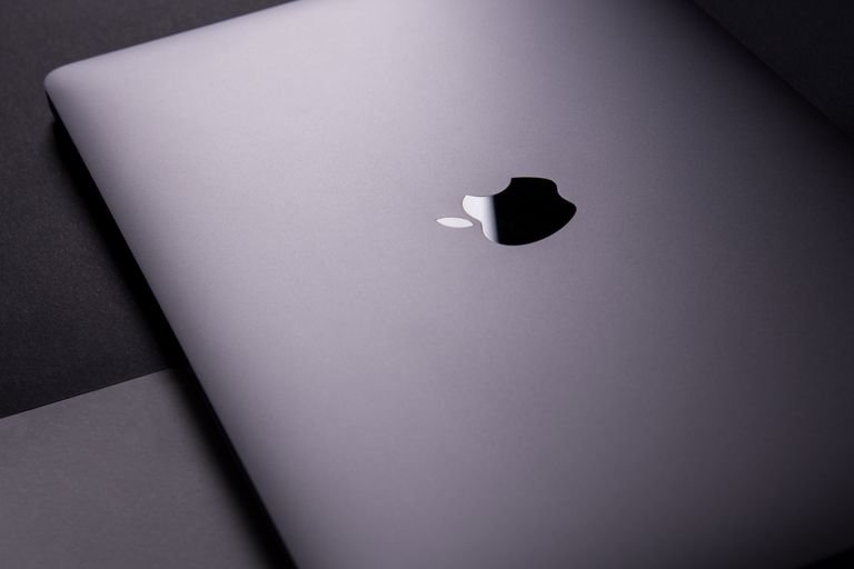 Close-up of a sleek, modern apple laptop featuring a minimalist design on a dark surface.