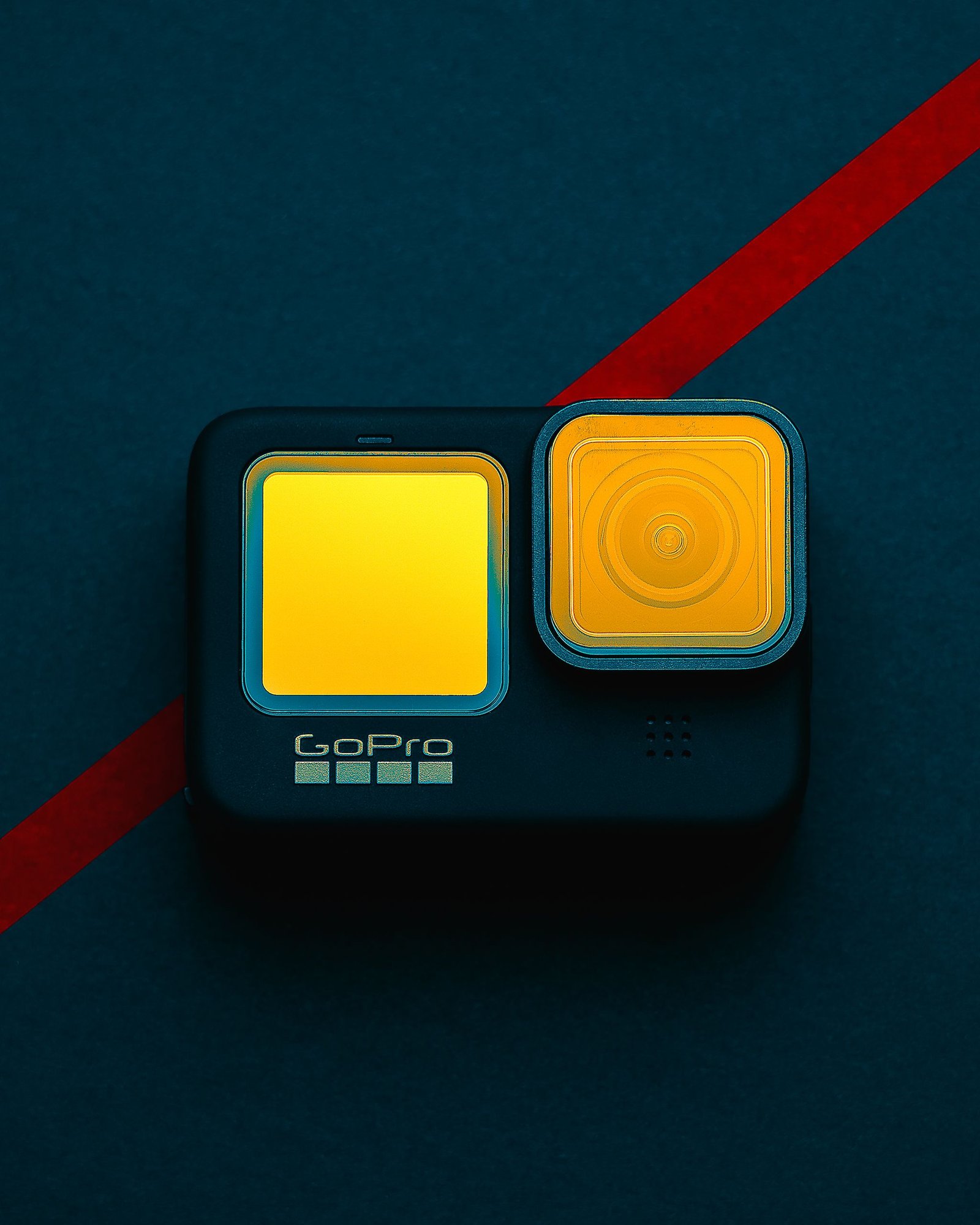 A GoPro camera featuring vibrant filters, placed on a dark background with a red streak.