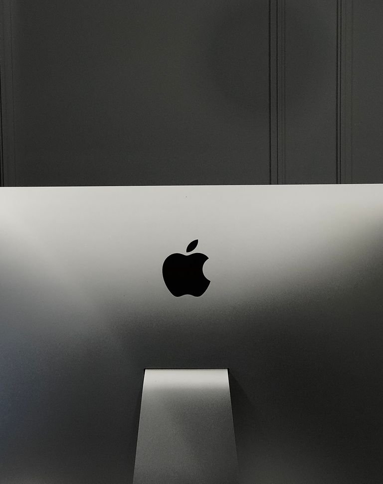 Close-up of an Apple iMac in a minimalist setup, showcasing its sleek design and elegant branding.