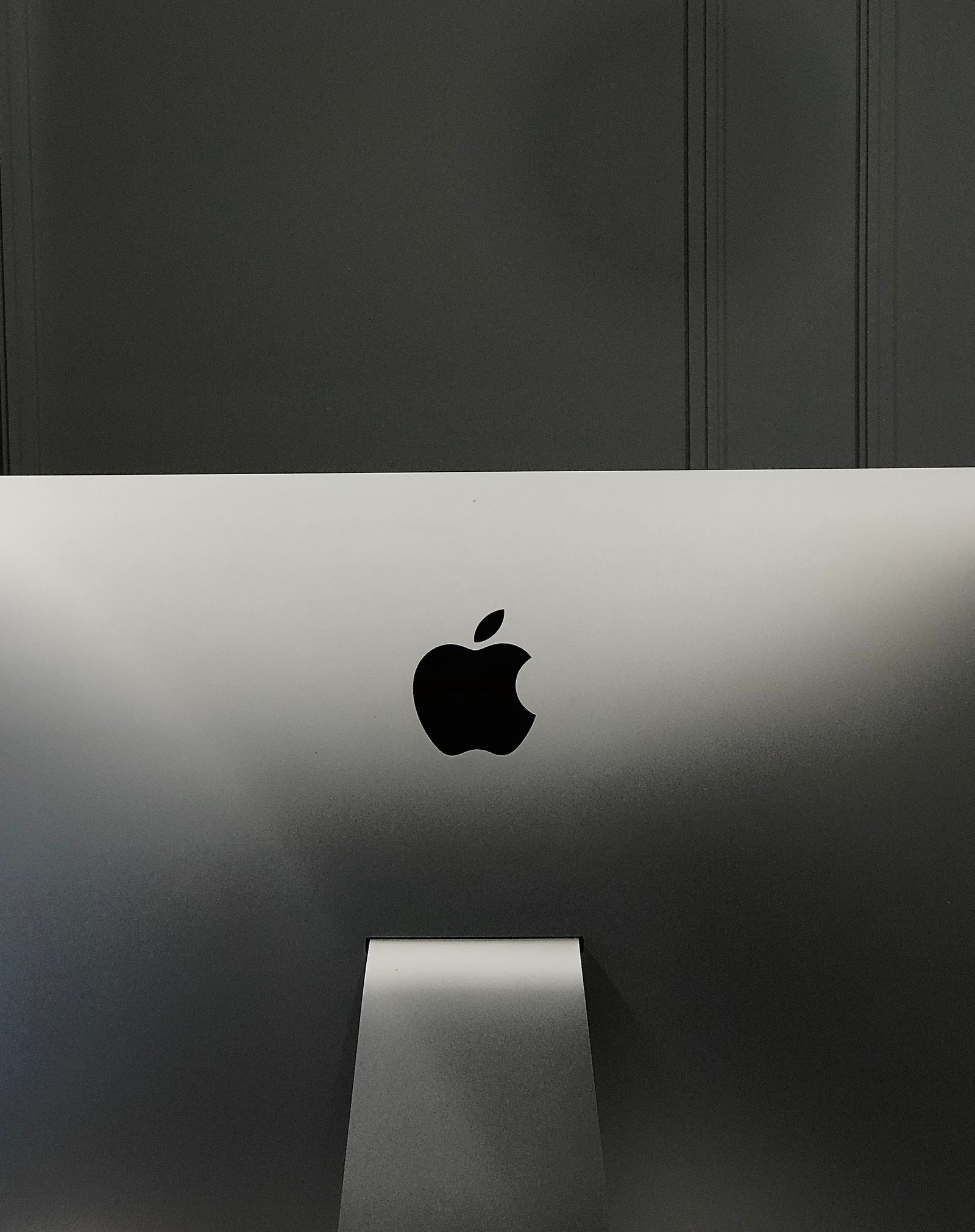 Close-up of an Apple iMac in a minimalist setup, showcasing its sleek design and elegant branding.